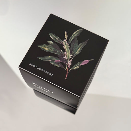 Botanical bay leaf illustration on top of Unundone’s “Rest Isn’t Selfish” candle packaging