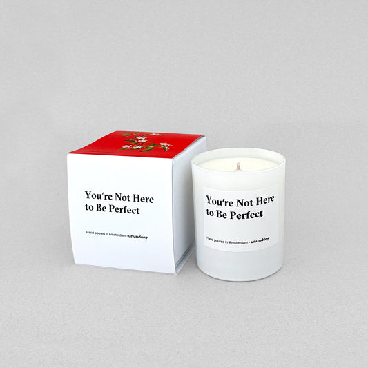 You're Not Here to Be Perfect candle and box set from Unundone — hand-poured in Amsterdam with emotional affirmation label.